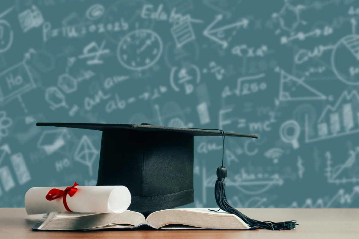 Graduation cap with diploma on book
